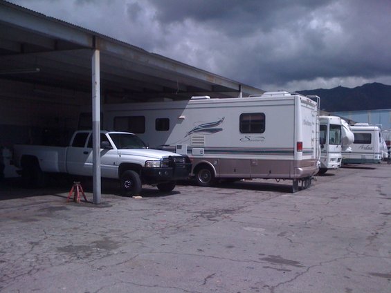 1997 Dodge 3500 pickup truck parked under a carport, with several RVs lined up behind it