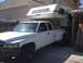 1997 Dodge 3500 - A white 1994 Dodge Ram 3500 dually pickup truck is equipped with a Lance camper shell and parked in a driveway.