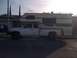 1997 Dodge 3500 - A white Dodge Ram pickup truck is outfitted with a large camper shell, parked on a residential street.