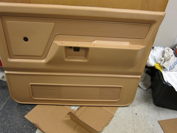 Tan interior door panel with horizontal ribbed speaker grille