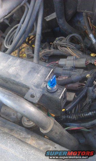 Engine bay with a blue toggle switch installed on a black box