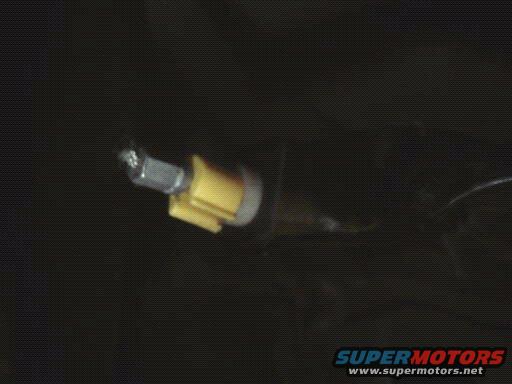 close-up of throttle cable connection with yellow plastic clip and metal bolt