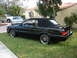 1992 Infiniti M30 - A black convertible is parked on a grassy lawn in front of a house, with two other vehicles visible in the background.
