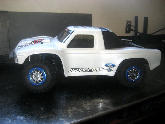 White RC truck with blue rims and JConcepts branding