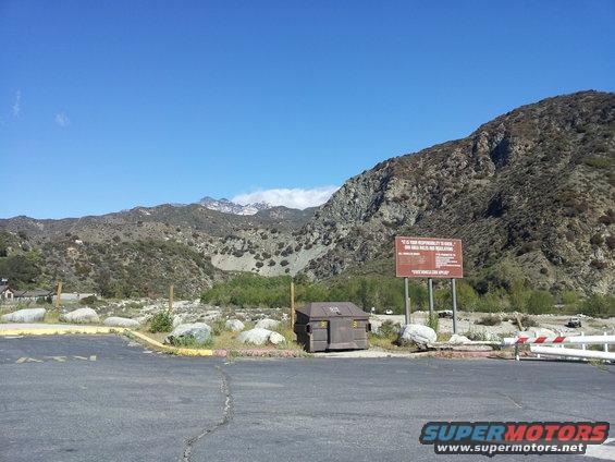 Mountainous landscape with a sign and dumpster