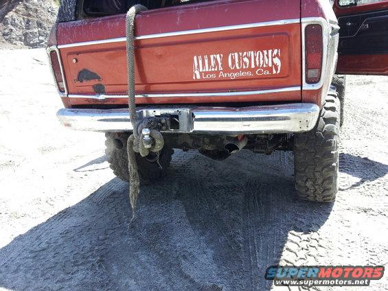 Red 1978 Ford Bronco rear with chrome bumper, tow hitch, and 'Alley Customs Los Angeles, Ca.' decal