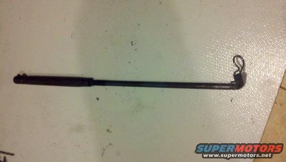 Dark metal rod with a black handle on one end and a bent L-shaped piece with a loop on the other