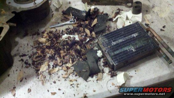 Heater core and debris on a workbench, with a ratchet nearby