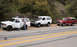 1994 Ford Bronco - Three Ford Bronco SUVs are parked roadside, with two individuals attending to one of the vehicles.