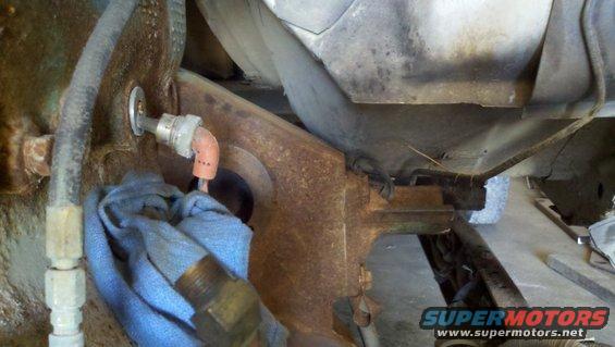 Close-up of engine bay component with blue cloth