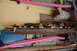 1988 Ford Bronco - A close-up view of a rusted metal frame and various tools, with pink foam tubes obscuring parts of the scene.