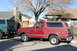 1991 Ford Bronco - Two Ford Broncos are parked on a residential street under a bare tree.