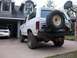 1985 Ford Bronco - The rear view of a white Ford Bronco shows its spare tire mounted on the back and a basketball hoop overhead.