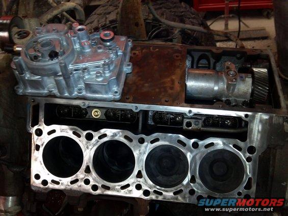 Engine block with four cylinders, oil filter housing, and oil pump assembly