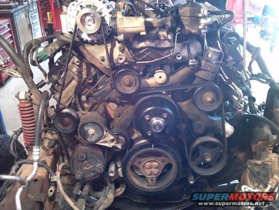Engine assembly with belts and pulleys, showing alternator and AC compressor