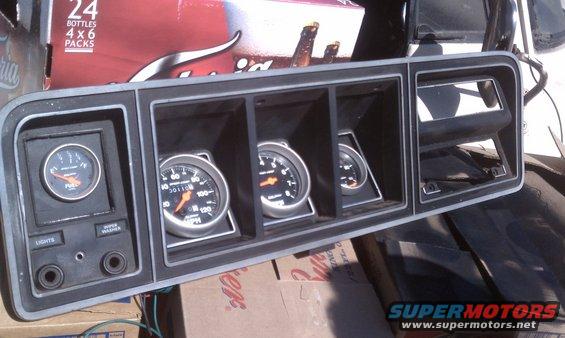 Dashboard gauge cluster with fuel, speedometer, and two other gauges. Also has light and washer buttons