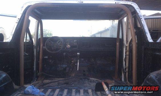 1978 Ford Bronco interior with a custom roll cage, showing the dashboard and steering wheel
