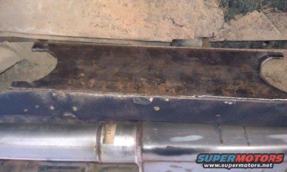 Exhaust pipe and rusty metal frame under a vehicle