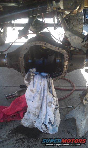 Close-up of an open vehicle differential with rags and tools nearby