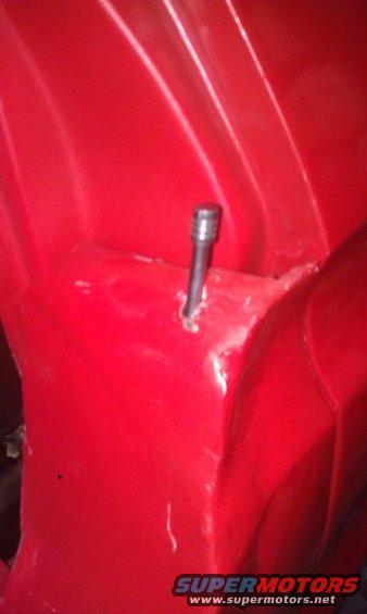 Red metal interior with a bolt protruding from the surface
