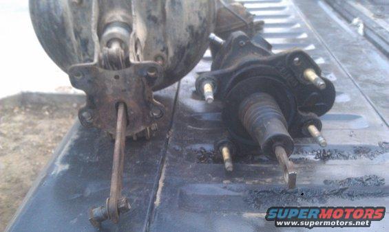 Two hydroboost brake boosters on a dark surface