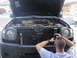 2004 Nissan Xterra - Man works on the engine of a 2004 Nissan Xterra with the hood open.