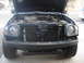 2004 Nissan Xterra - The front of a dark SUV is shown with the hood open, revealing the engine compartment and radiator.