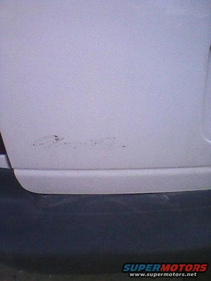 Rear bumper corner with scuffs and a dark lower trim piece