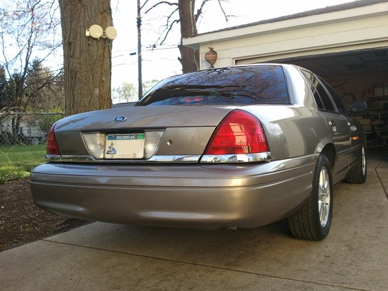 Tan 2007 Ford Crown Victoria rear quarter view, parked in driveway near garage