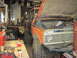 1978 Ford Bronco - 1978 Ford Bronco undergoing work in a garage, hood raised to reveal the engine bay.
