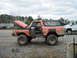 1978 Ford Bronco - Orange 1978 Ford Bronco undergoing work, with hood and door open. A white truck is parked nearby.
