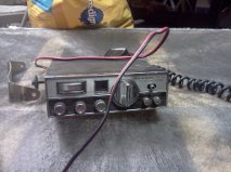 CB radio with chrome accents and knobs, connected by red and black wires