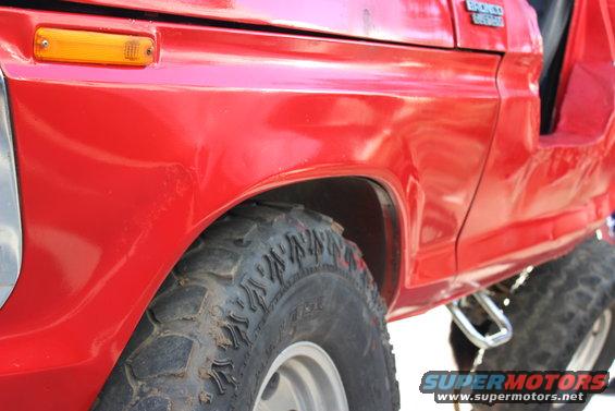 Red 1978 Ford Bronco side view showing fender, tire, and Bronco badge