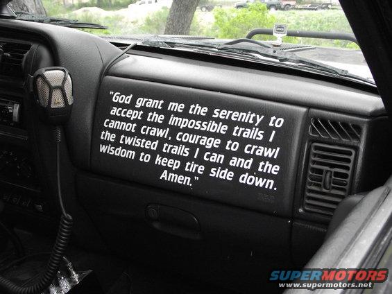 Interior shot of a Jeep with a prayer decal on the dash and a CB radio