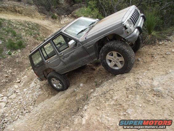 Gray Jeep Cherokee XJ climbing a rocky incline