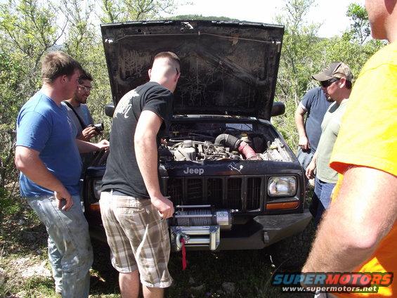 Black Jeep Cherokee XJ front view with hood open, winch installed
