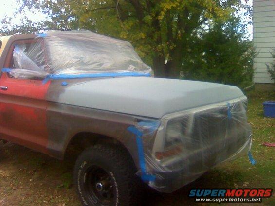 1979 Ford Bronco front end covered in plastic and tape, ready for paint