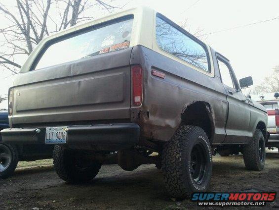 Brown 1978 Ford Bronco, rear view, showing damage on rear quarter panel and faded paint
