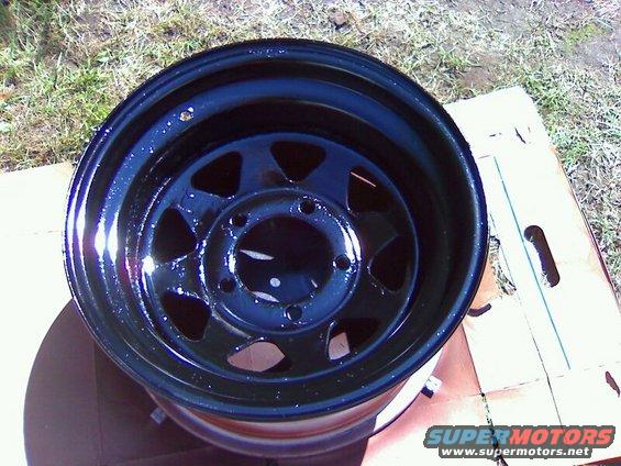 black steel wheel with 5 lug holes and triangular cutouts