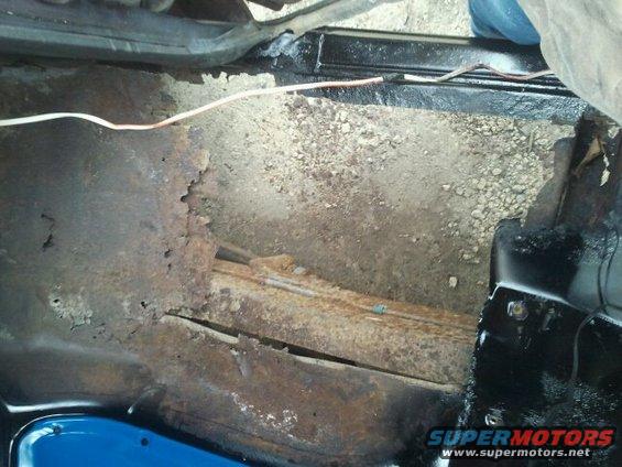 rusted floor pan and frame with exposed wiring