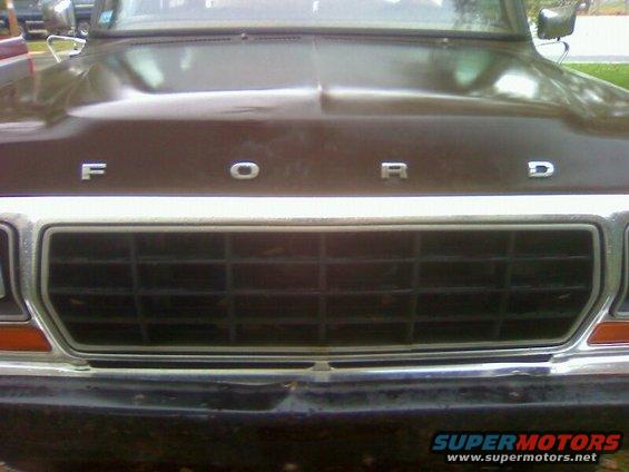 Brown Ford truck grille with horizontal bars and chrome trim, hood with 'FORD' lettering