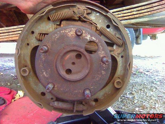 Drum brake assembly with springs and hardware, held by a hand