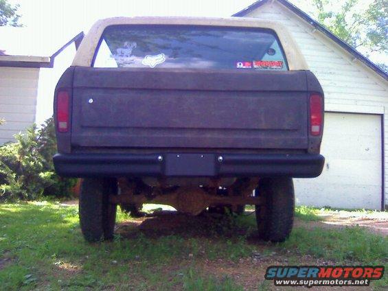 Rear view of a weathered 1978 Ford Bronco with a tan top and a black bumper