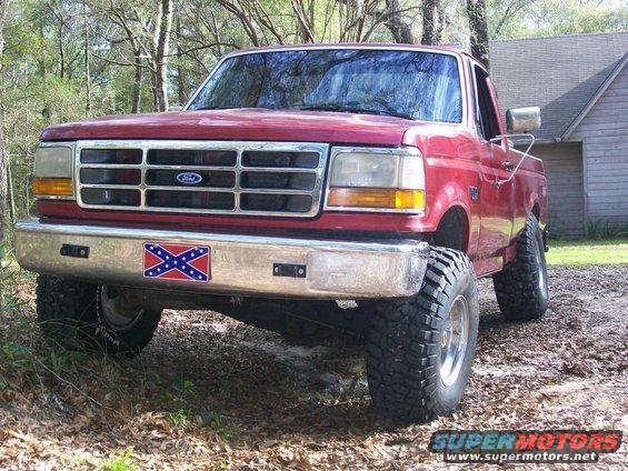 Red 1993 Ford F-150 front view with lifted suspension