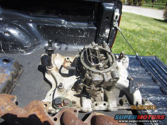 Carburetor and intake manifold on truck bed