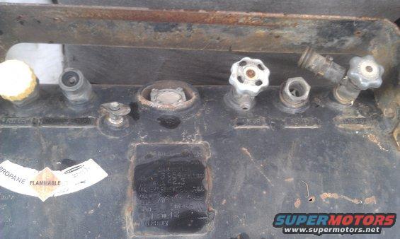 Propane tank fittings with valves and connectors, some with yellow caps