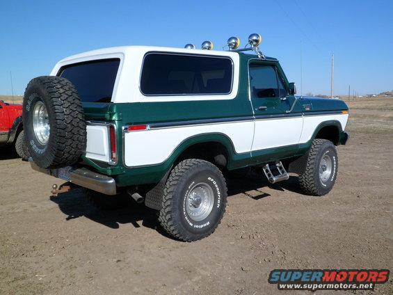 Green and white 1979 Ford Bronco rear quarter view with spare tire