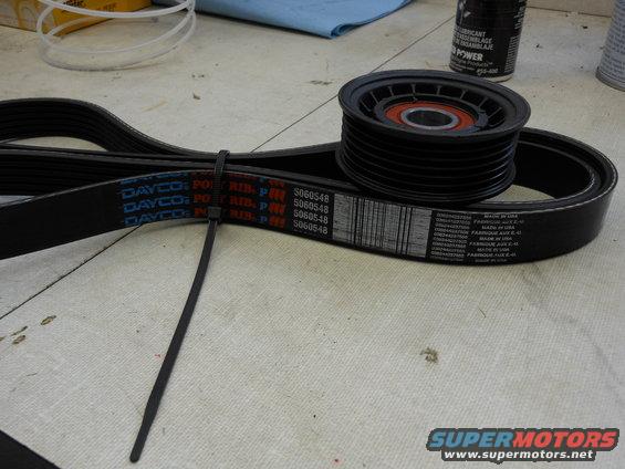 Serpentine belt with DAYCO branding and part number S060548, next to a pulley