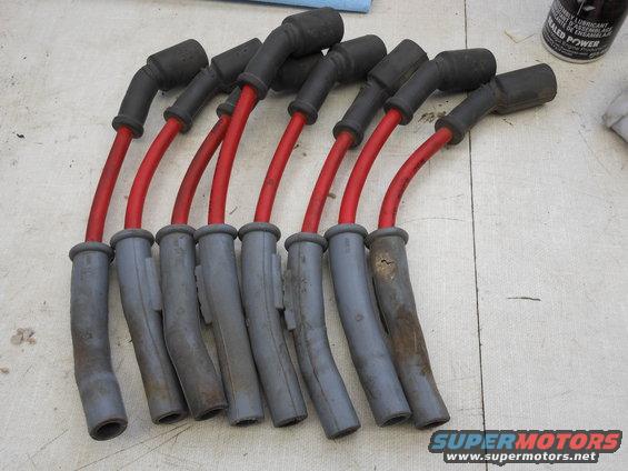 Set of red spark plug wires with black boots and gray boots