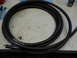 2005 Honda CR125R - Coiled black braided hose on a workbench surface.